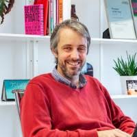 Paul Massey sitting at desk with laptop